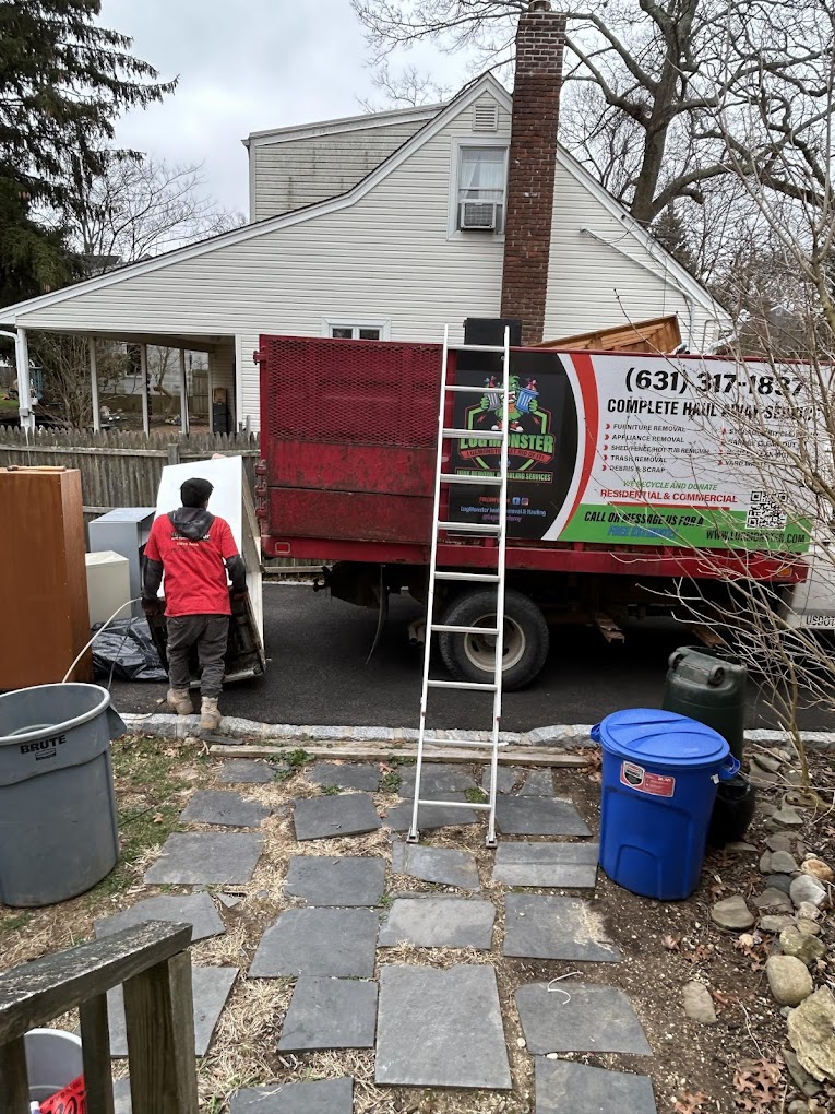 LugMonster junk removal truck in Long Island with worker loading items for haul-away service.